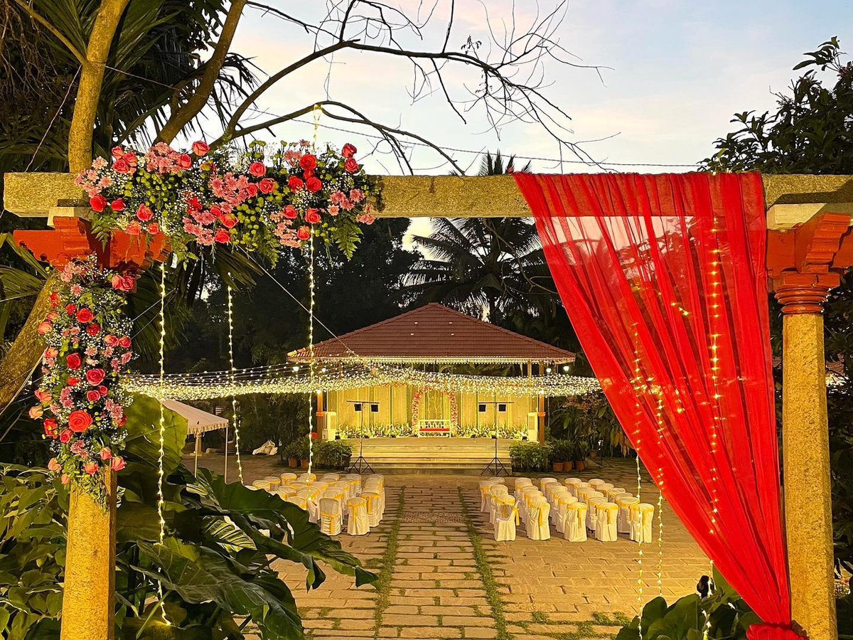 The mandap pavilion lit up at dusk with fairy lights